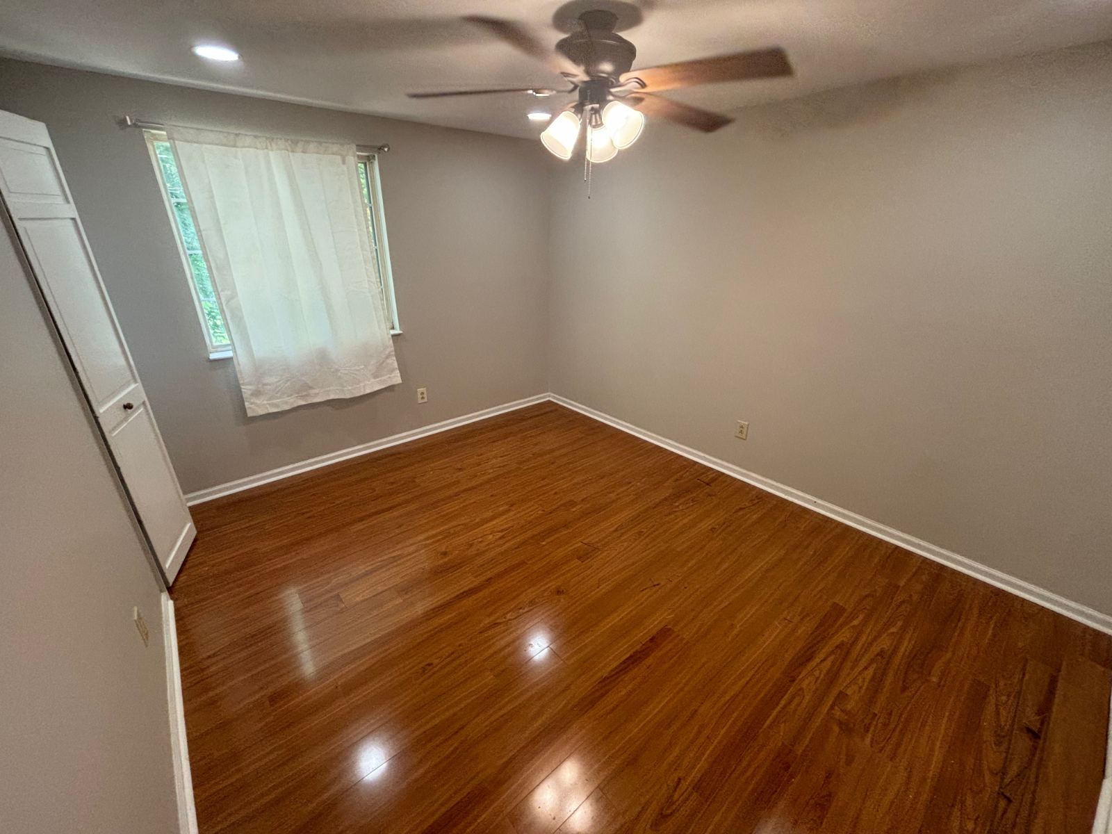 Glossy warm brown plank flooring in a finished bedroom